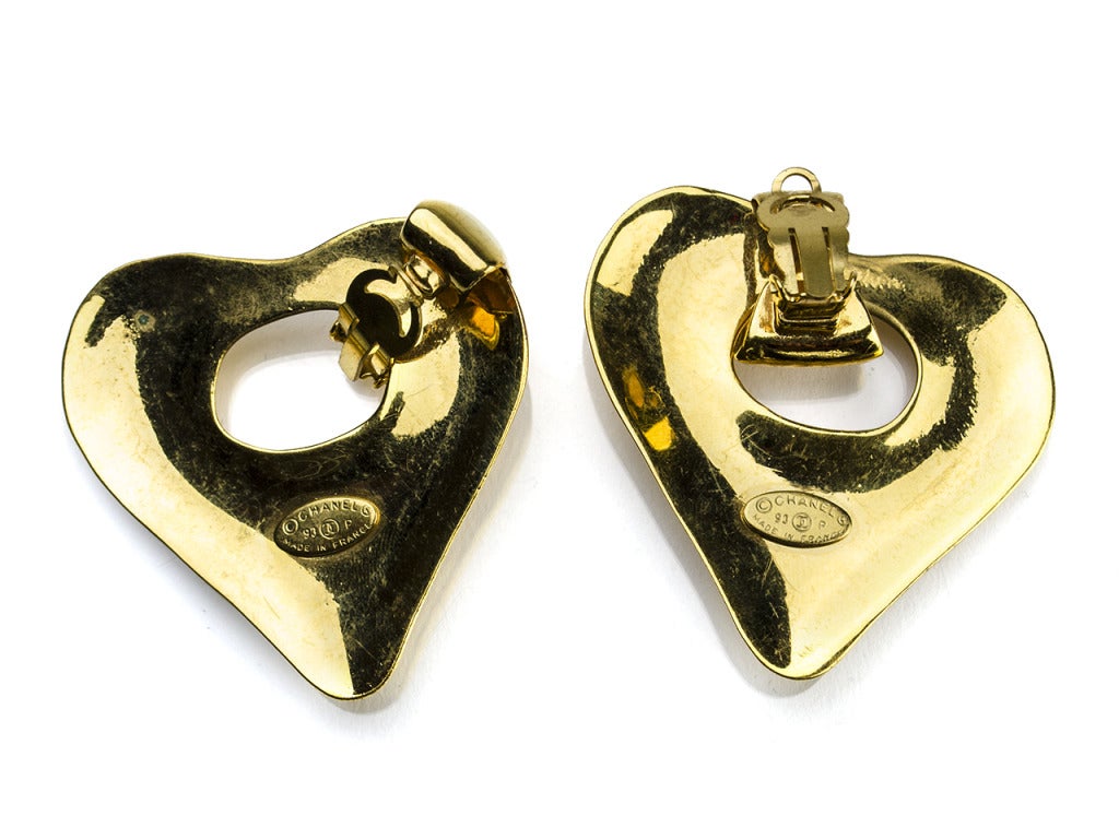 Don't hit the dance floor in anything less than Chanel! The Chanel 93P heart earrings will keep you glittering from the hip-hop club to the country concert with their funky twist on the standard large gold hoop. Molded heart shape features