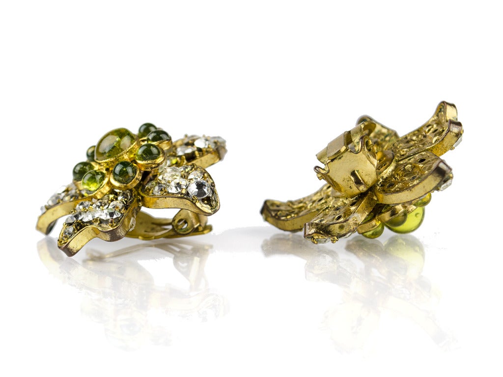Channel the inner garden fairy, mermaid or mythical maiden of your choice with a healthy dose of chiffon and the vintage Chanel Season 29 rhinestone floral earrings. The two floral shapes of these yellow gold, clear rhinestone and green glass