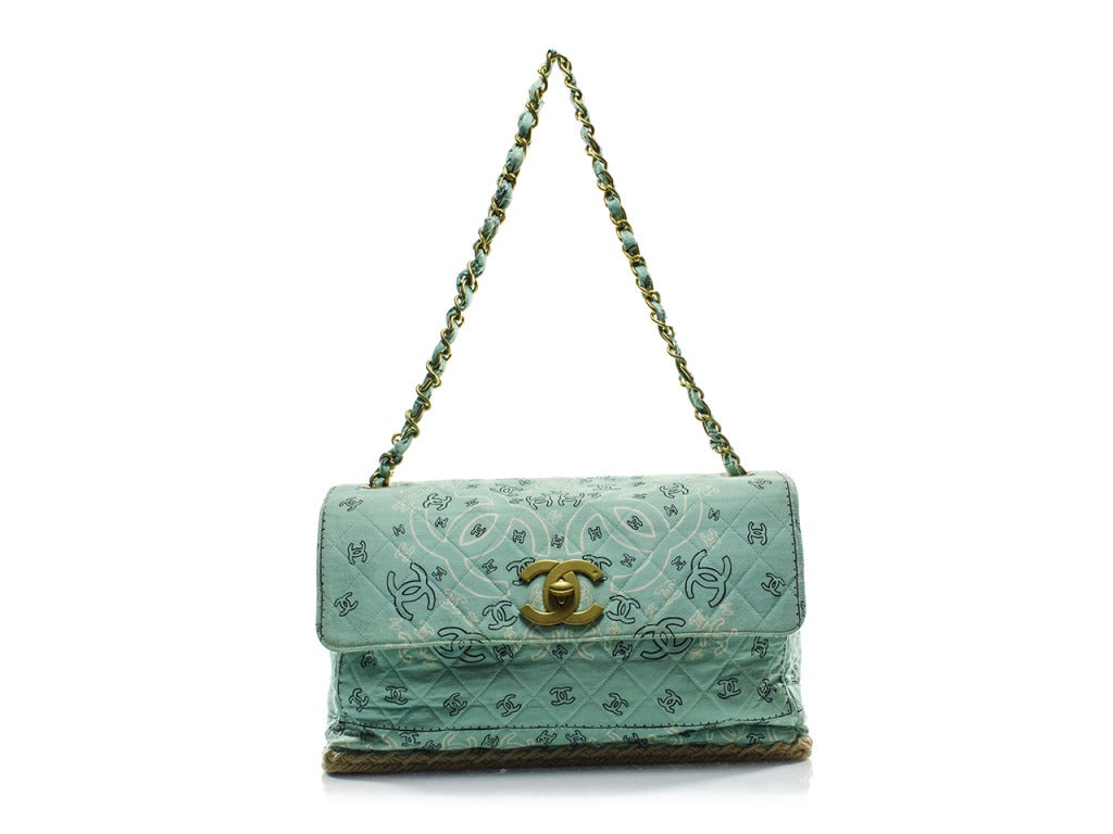 A mint green, whimsical must-add to your Chanel collection! The Chanel espadrille flap bag features soft mint green cloth exterior printed with black and white freehand versions of the classic interlocking CC logo and a fresh, summery espadrille