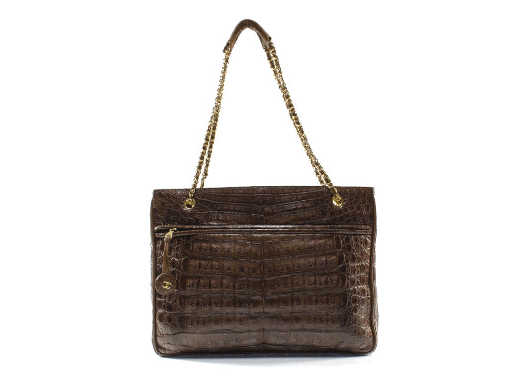 You and your wardrobe deserve the incredible luxury of the vintage Chanel crocodile tote. Timeless brown crocodile leather is accented with a large front and back pocket and yellow gold hardware. Interlocking CC charm gleams subtly from the back