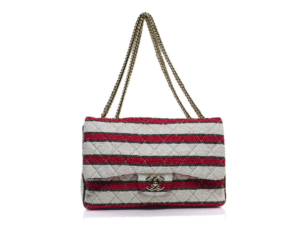 One of a kind & extremely rare this beauty will be sure to turn heads! Unlike the traditional jumbo flap this flap is constructed of red, white and blue tweed stripes. This bag also features silver tone hardware, one exterior pouch pocket which is