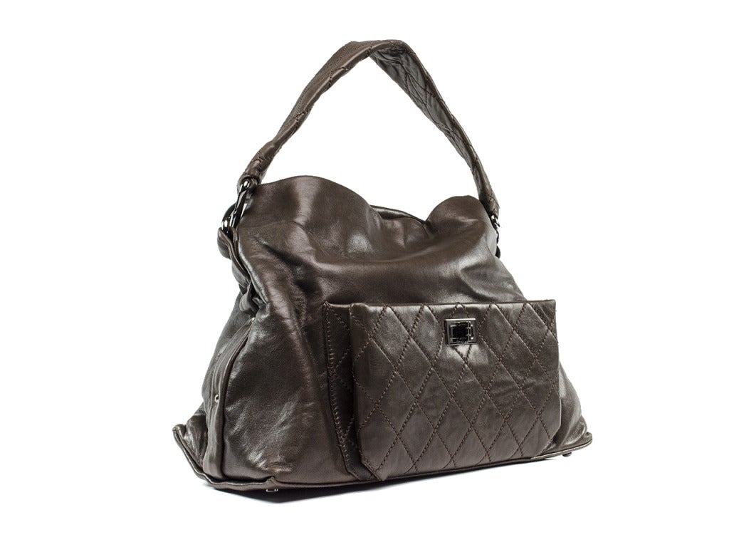 Throw life's essentials in this everyday tote! This beauty features espresso brown lambskin leather throughout, traditional Reissue closure, quintessential diamond patchwork at front pouch, leather handle, silver tone hardware. Interior features one
