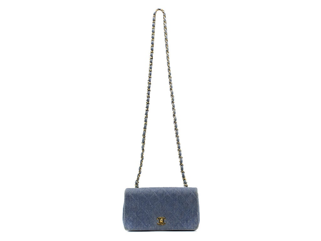 Dismember the idea of 'summertime saddness' with this fun denim mini flap! This bag features subtle yet quintessential diamond pattern detailing throughout, gold tone hardware, flap detail. Interior features two pouch pockets. Made in