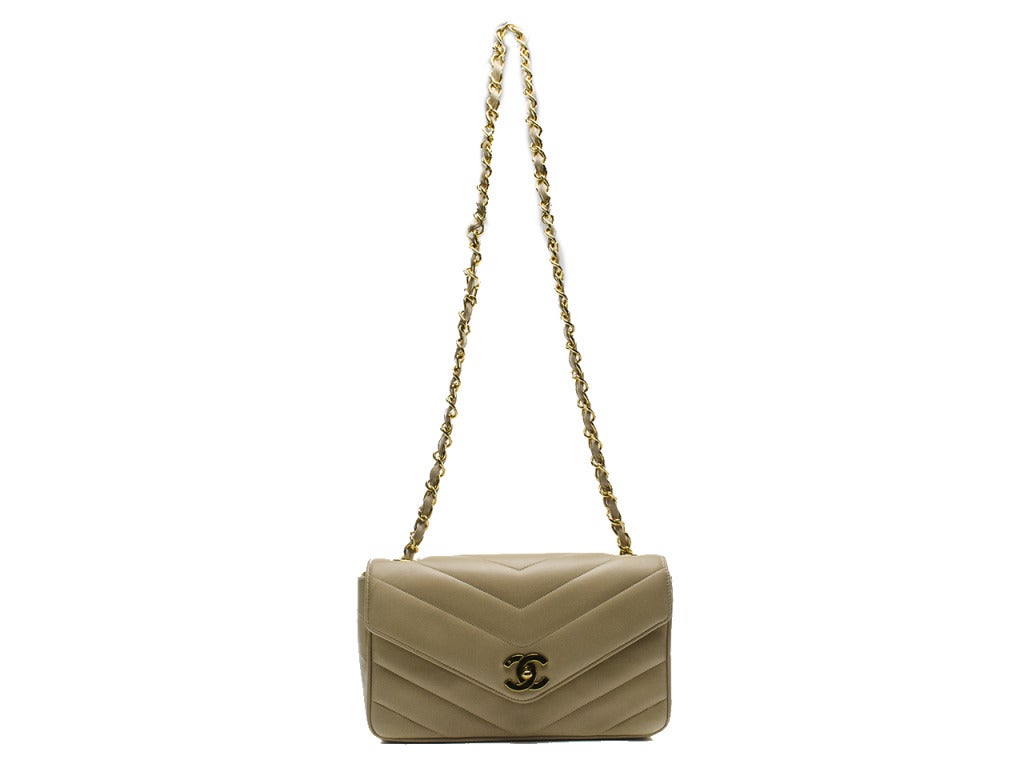 The perfect dose of classic Chanel! This bag features beige lambskin leather throughout, gold tone hardware, one back pocket and chevron stitching throughout. Interior features one zip pocket and one pouch pocket. Made in France.

Includes: