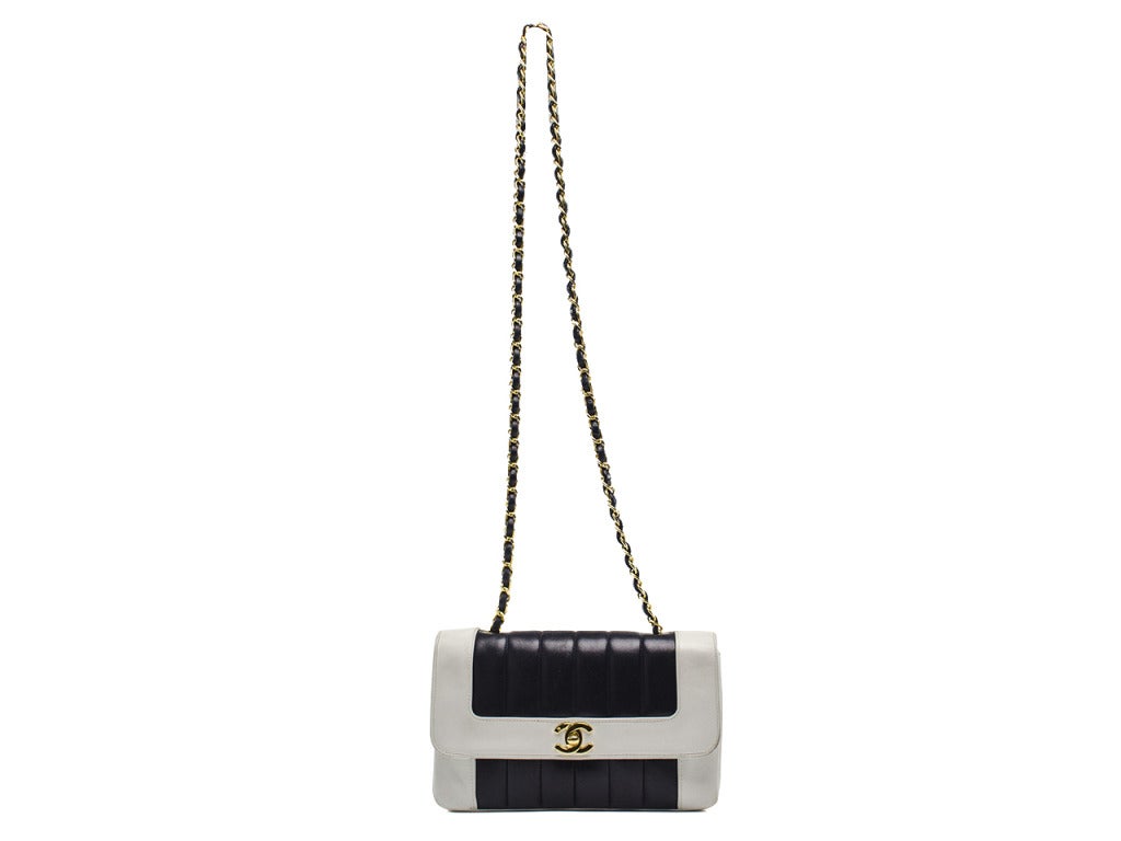 A timeless classic! This Chanel vintage flap features navy blue & white colorblocking detail with a traditional flap front, gold tone hardware. Interior features one zippered pocket and one pouch pocket. Made in France.

Dimensions: 8.5
