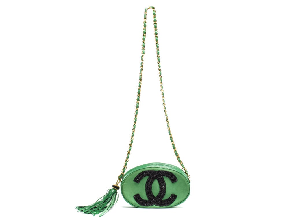 Extremely rare! Chanel green satin & leather oval sequin shoulder evening bag is the perfect accent to a glamourous night on the town! This bag features a green satin face with Chanel interlocking 'CC' detail in black sequins, gold tone hardware,