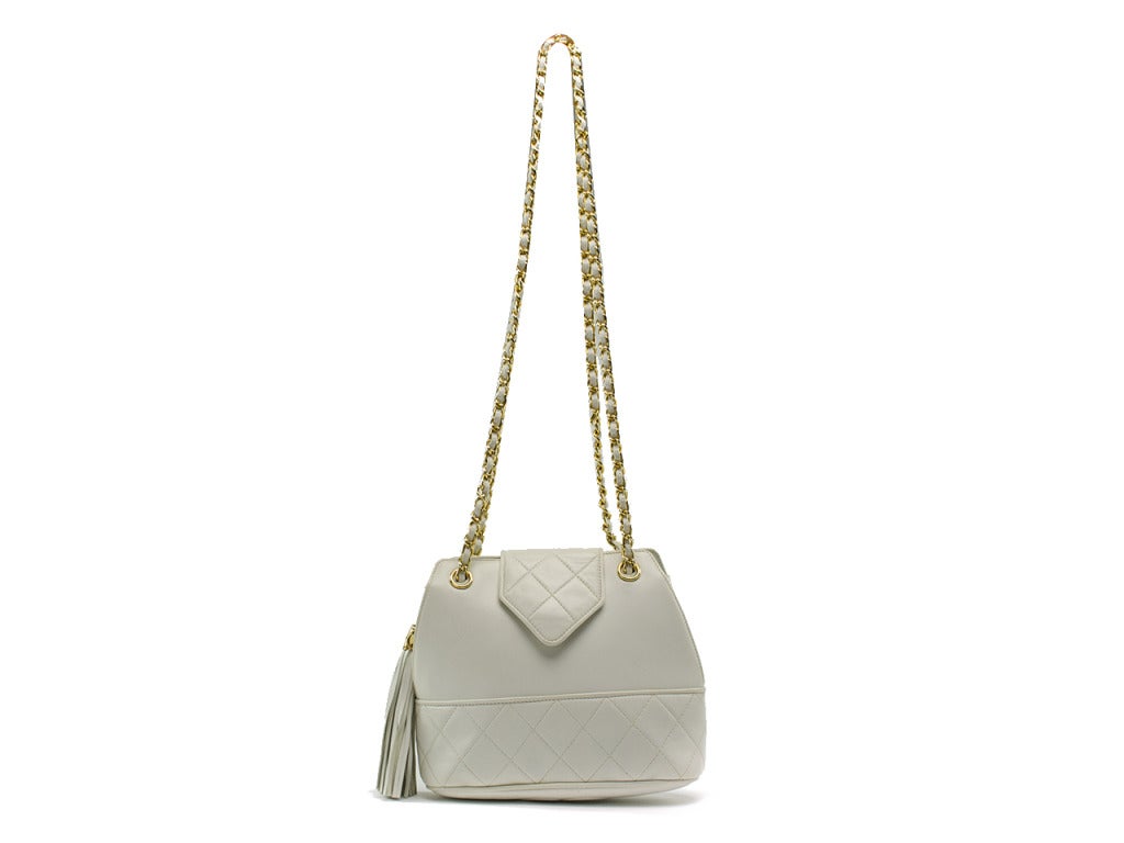 A rare vintage find circa 1989! This Chanel Signature Matelasse gold plated shoulder bag is featured in white lambskin leather, 18k gold plated chain dual shoulder straps, the Chanel 'CC' emblem embroidered at the bottom, the mini flap with hidden