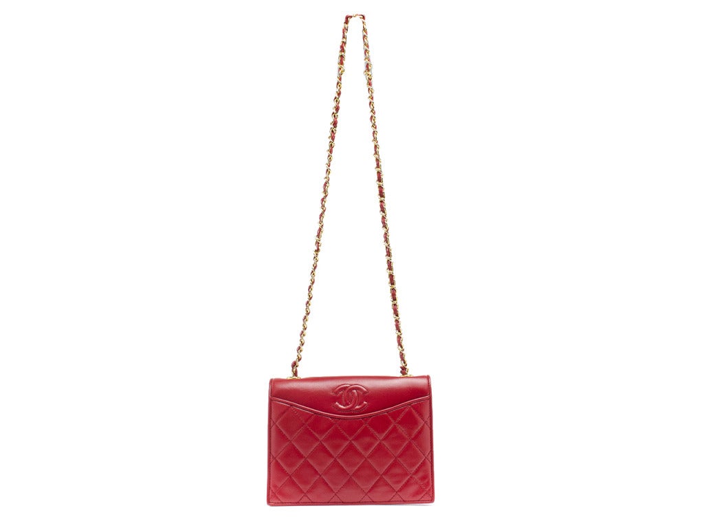 Such a fun vintage bag to add to your collection! This gorgeous Chanel bag features red lambskin leather throughout, iconic Chanel 'CC' detail at front of the bag, quintessential diamond pattern throughout front, flap style, subtle front and back