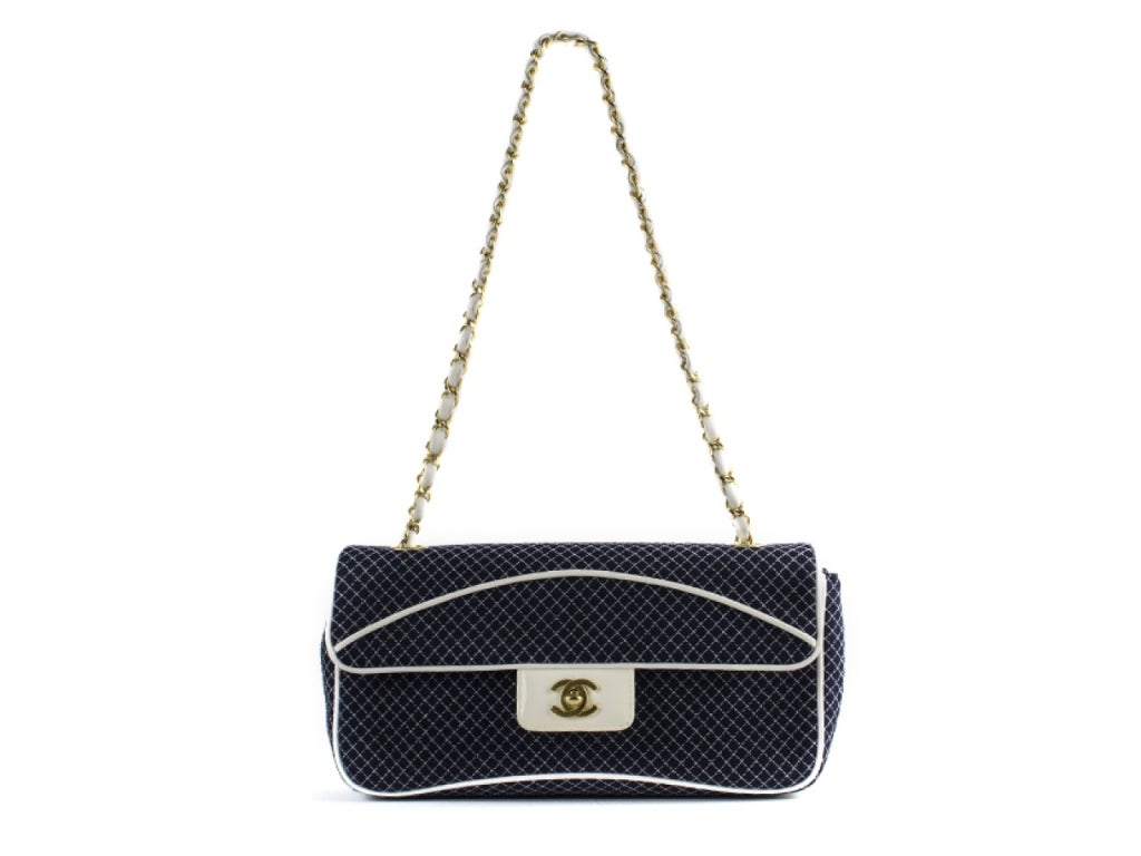 An elegant & sophisticated handbag that will not A navy hue that is intricately quilted. Contrasts beautifully with calfskin white piping. Brushed gold hardware with classic “CC” turnlock puts the finishing touch on this bag. Pristine condition.
