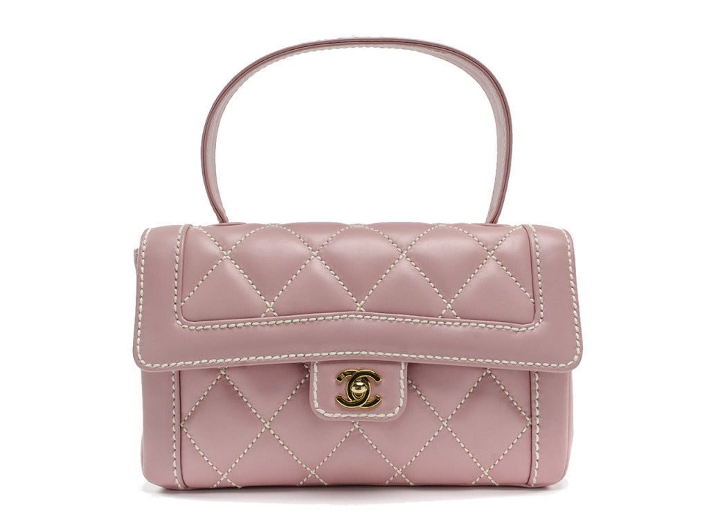 Such a rare piece--just in time for spring! This bag is featured in a gorgeous pink lambskin leather with pink stitching throughout, gold tone hardware, interlocking Chanel 'CC' clasp closure, one back pocket. Interior features one front pocket and