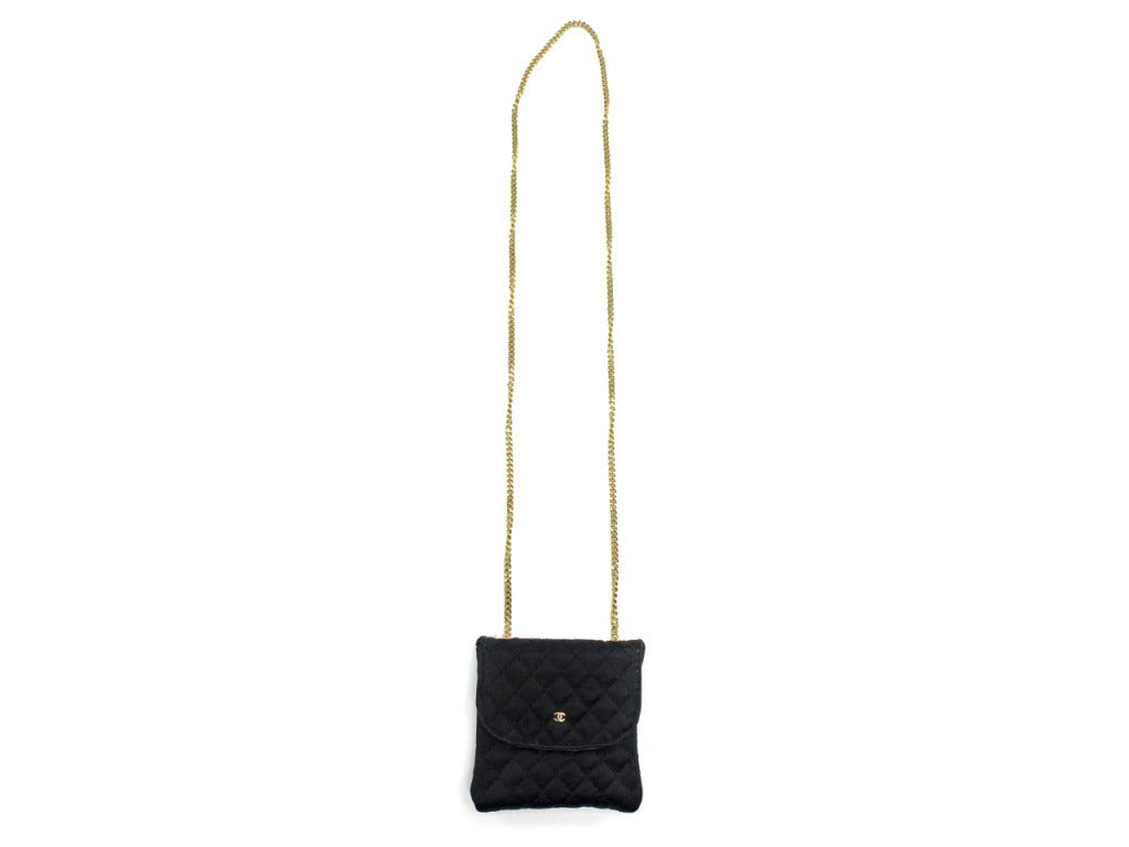 Wear it as a necklace or wear as an evening bag! A fun accessory to any fashionistas wardrobe! This Chanel bag is featured in black satin with gold tone hardware, single strap detail, Chanel 'CC' logo on front of the bag, quintessential diamond