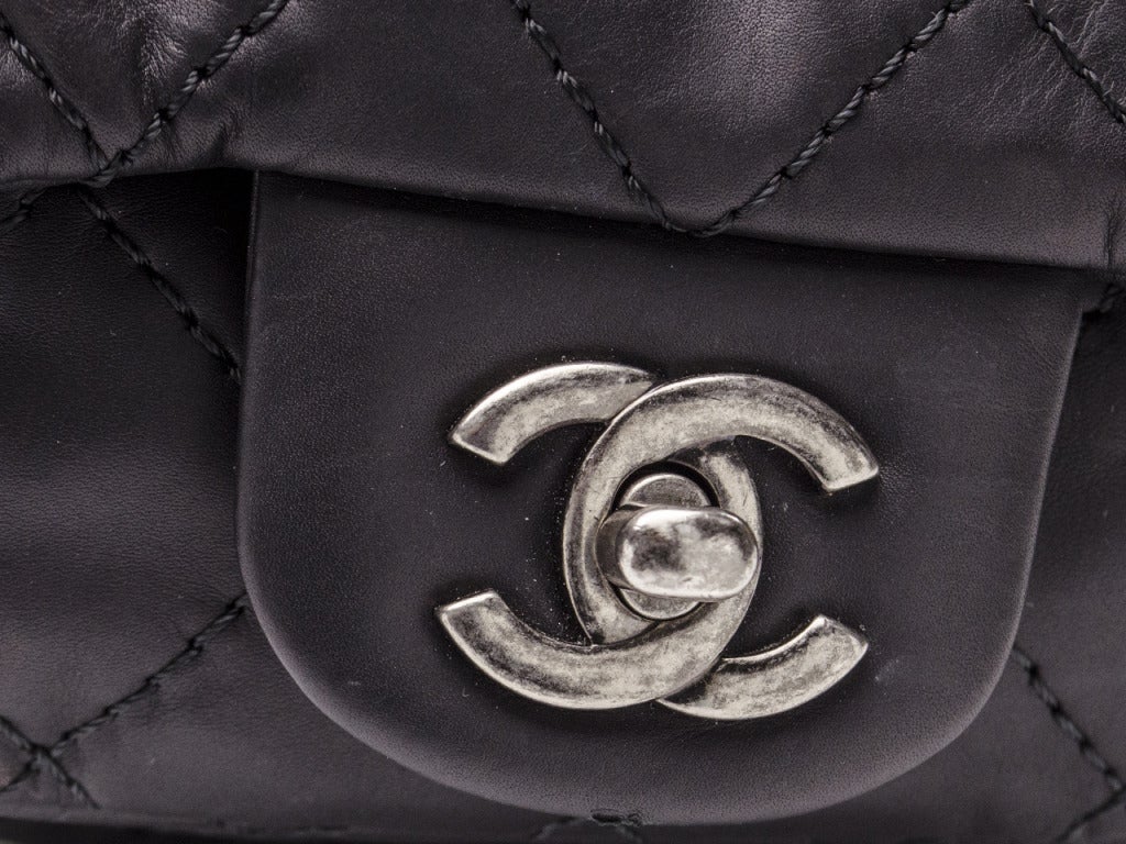 Extremely rare & hard to find! Chanel black lambskin quilted leather, silver hardware, two front quilted leather pockets, zip front, one back pocket. Interior features one zippered pocket.

Includes: Authenticity card, box & dust