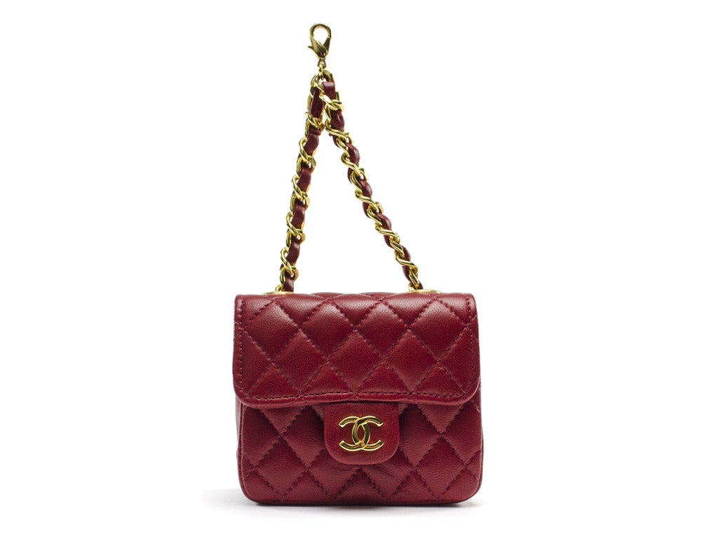 This dainty miniature flap bag is a must-add to any Chanel lover's collection! Quilted red lambskin leather is structured into a bite-sized version of the classic Chanel flap bag, complete with yellow gold interlocking CC charm at snap closure and