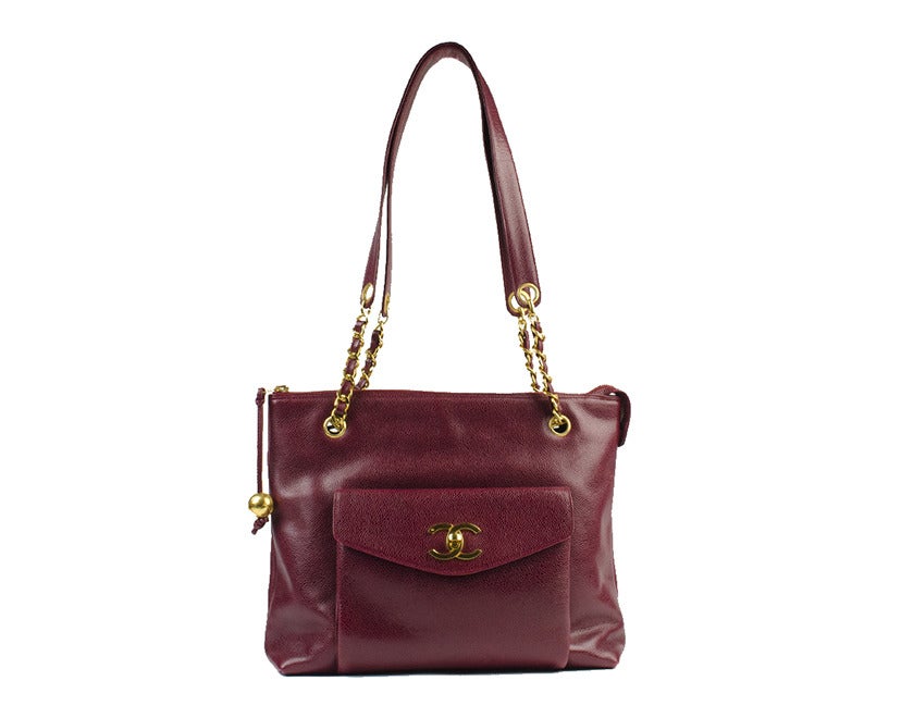 This red leather Chanel tote is the perfect accessory for any occasion, from the office to weekend errands and everywhere in between. The interior and front pocket provide ample space, while gold accents and 'CC' logo add a touch of class.  12.5