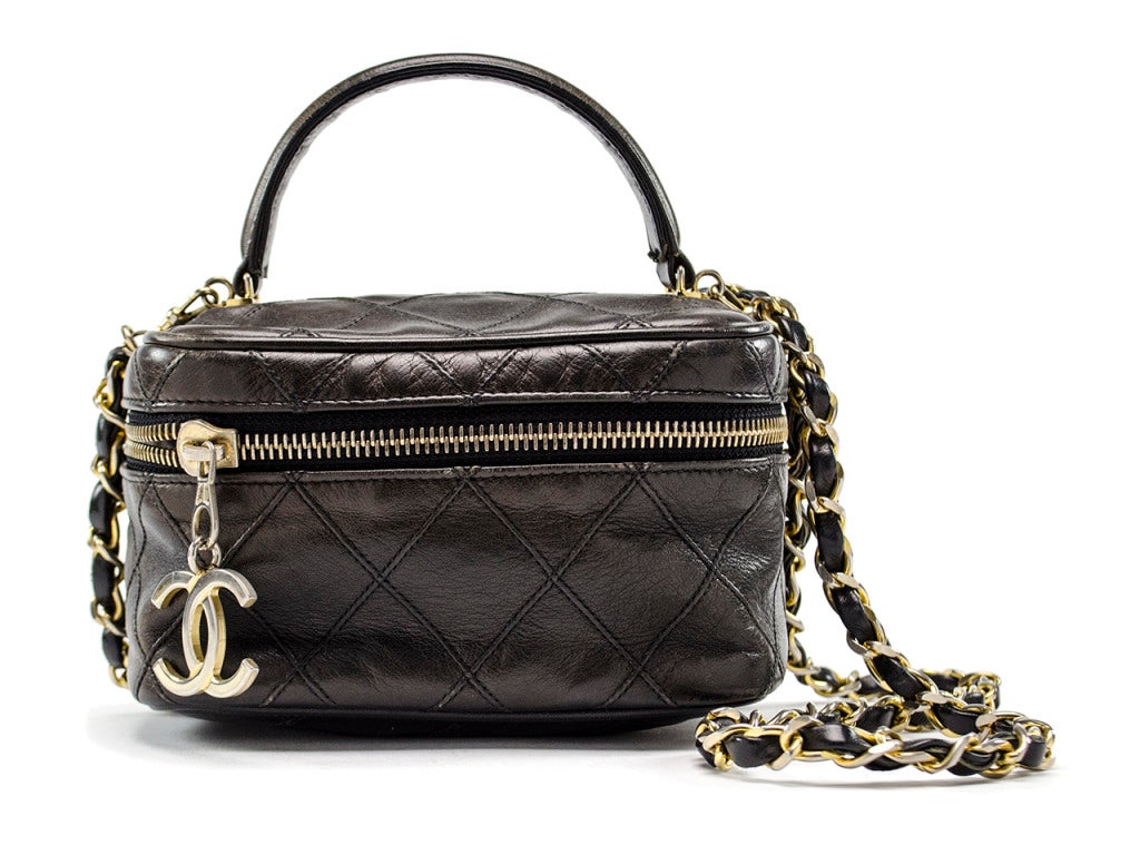 Use this sweet little bite of Chanel as a vanity or funky shoulder bag, or trade off between both! Buttery black quilted leather is constructed into a rounded square vanity with a top handle, yellow gold interlocking CC zipper pull and removable