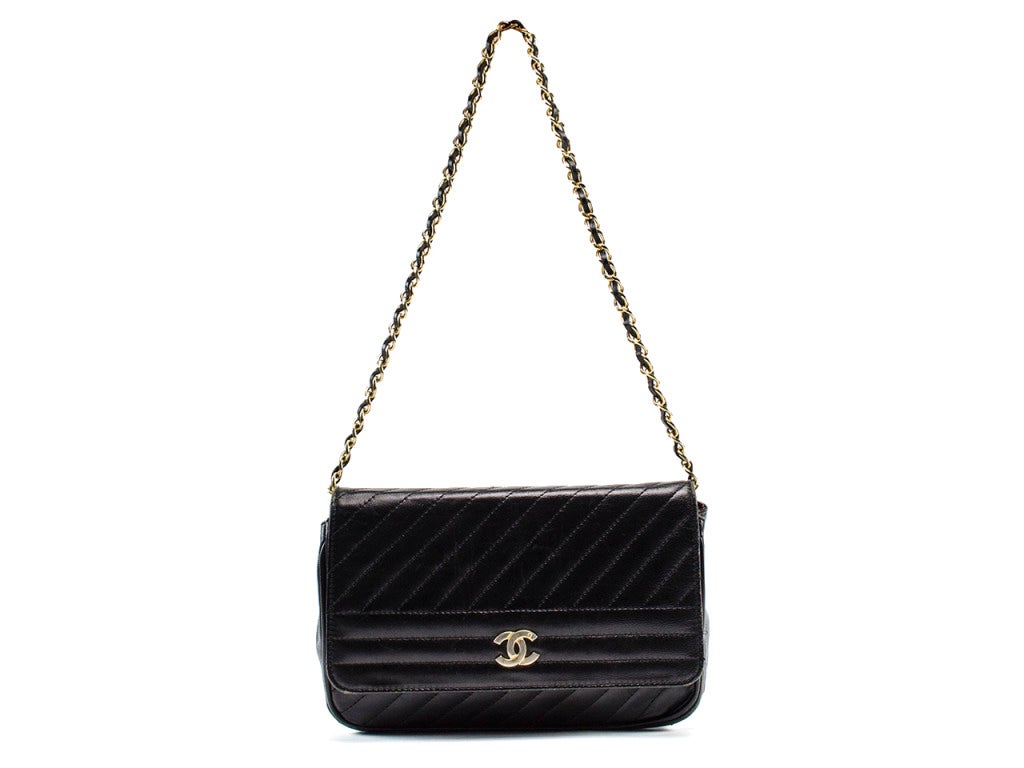 The Chanel vintage lambskin flap boasts standard style with vintage character. Whether dressed up or down, the black leather shoulder bag with diagonal and horizontal stripe stitching, gold interlocking CC charm and chain link and leather strap is