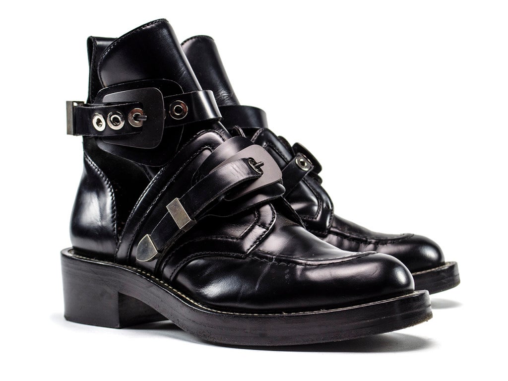 Blogger fav! Balenciaga Smooth calfskin leather apron toe ankle boot with adjustable silver-tone buckle straps at vamp and shaft. Side cutout details and contrast welt stitching. 3.25