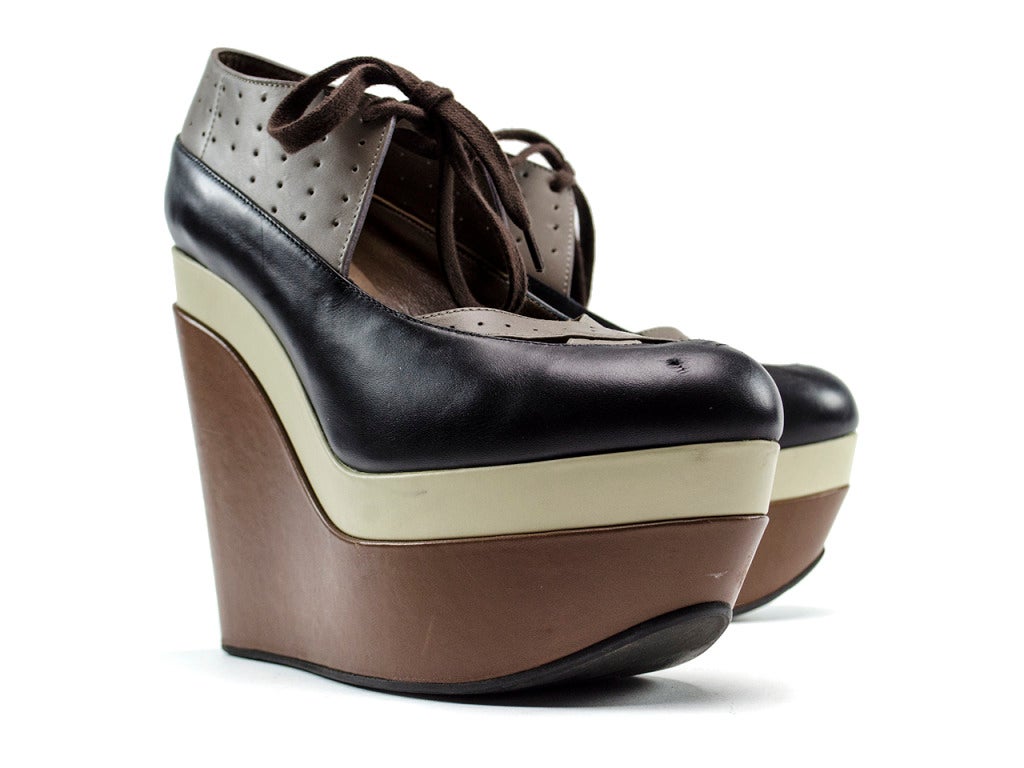 Lace-up front. Marni wedges: brown, cream and black perforated crossover detail at top, wedge heel measures approximately 115mm/ 5.5 inches with a 65mm/ 2.5 inch platform,leather round toe.