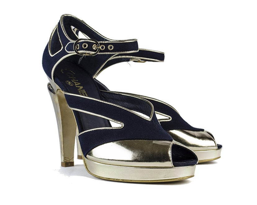 Dazzle the entire room with the fierce Chanel navy suede and gold peep-toe heels. Light gold heel, platform and vamp detailing shine against subtle-yet-classic navy suede, with cutouts on the sides and heel adding a flirty side to this commanding