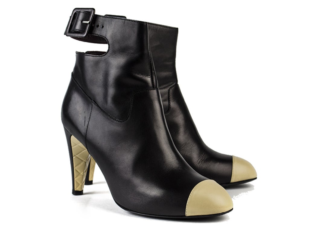 Oh la la! Slip on the Chanel black leather cap toe ankle boots and you'll be ready to jump on the back of a motorcycle and ride off into the night. Light yellow cap toe coordinates with light yellow quilting detail underneath heel, adding a soft