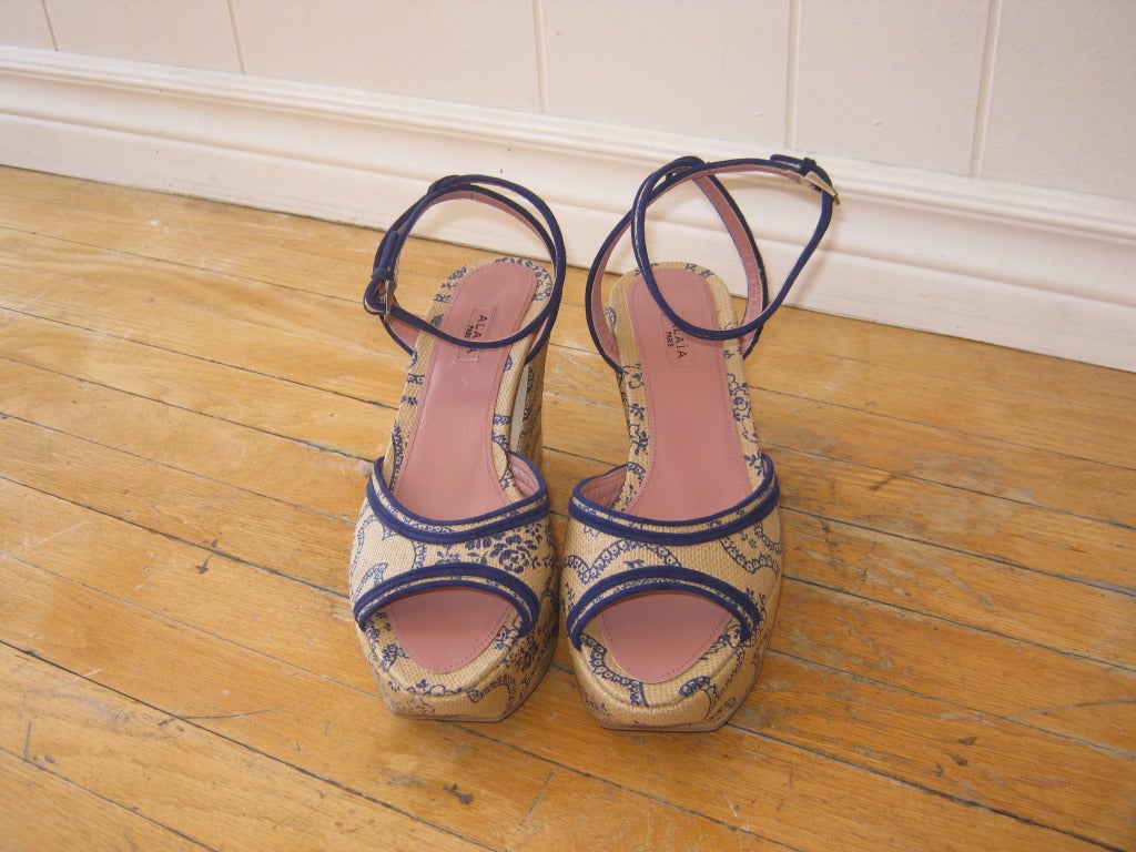 These platform sandals are made of coated canvas with suede trim, and the print is a delicate paisley.

As with most Alaia footwear there is a surprise design element, and in this case it is the crescent shaped peek-a-boo opening on the