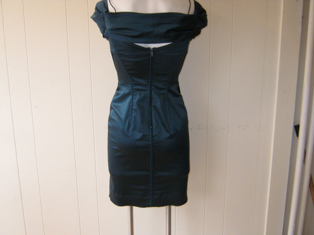 This is a body hugging dress with boned black under bra peeping through, pleated off shoulder detail, exposed seam detail under the bust as well as the upper part of the skirt. Although this is an off-shoulder dress there are two thin spagetti