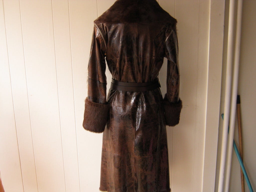 Stylish and cozy this chocolate brown distressed leather coat is completely lined with rabbit fur; a shawl collar and wide fur cuffs.

This size 40 Italian (fits 4-6 us)coat, comes with a double strand Dolce & Gabbana comes with detachable sleeves