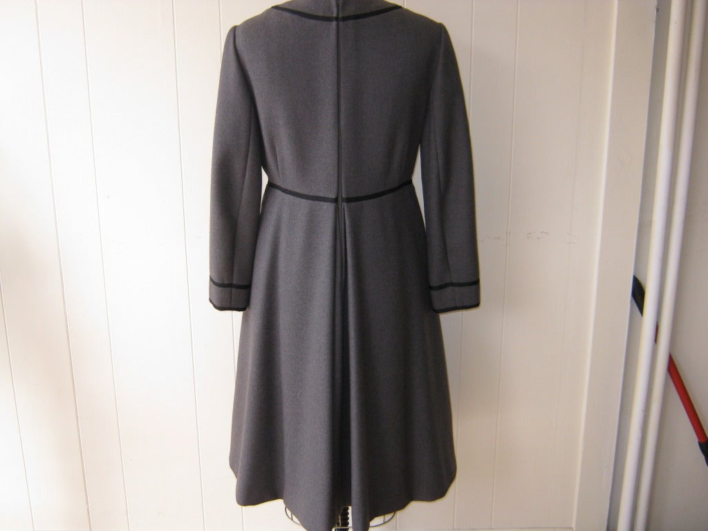 This 1960s Geoffrey Beene dress is made of grey wool crepe with gros grains details, covered buttons and wonderful pleating. It is in excellent condition for its age and zips in the back. I would estimate the sizing to be 8-10 US, and was bought
