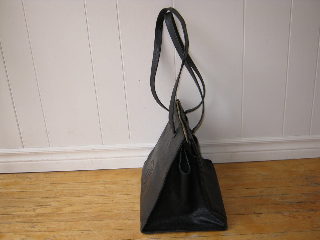 This is a black caviar leather bag which is structured and large enough to double up as an overnight bag or carry your laptop and other everyday necessities. 

There is an open slide pocket in the back, two zipped pockets on the inside and a zip