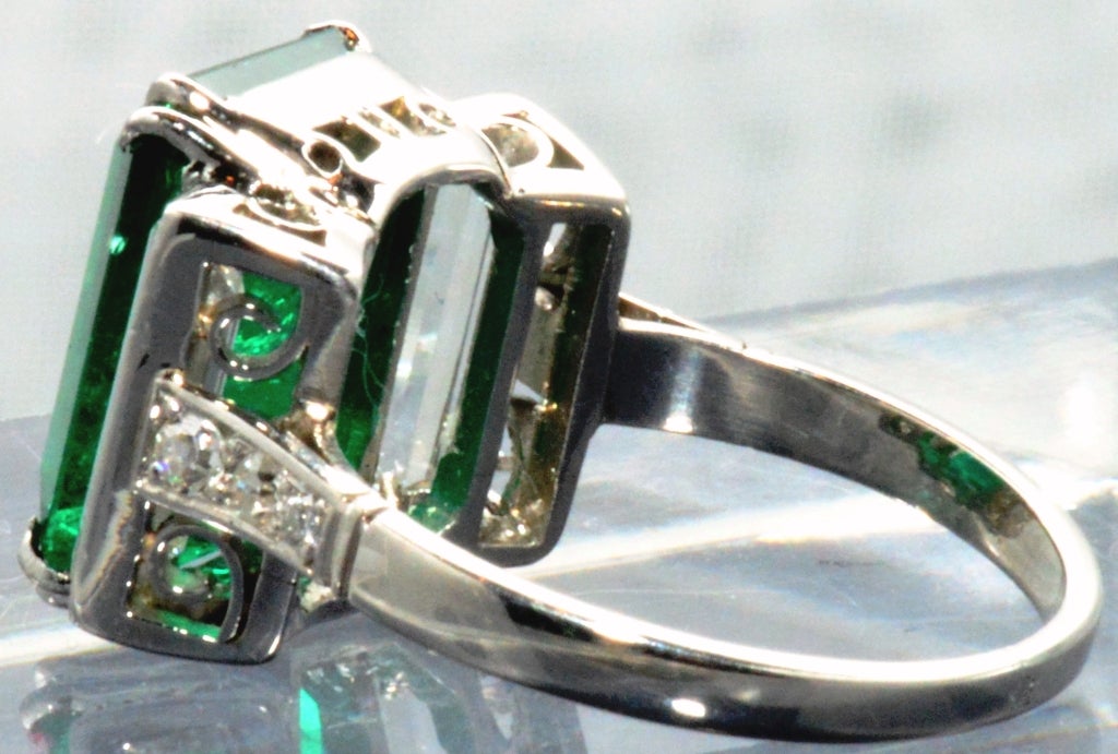 Art Deco Platinum and Diamond Ring containing om Emerald Cut Emerald Wt: 4.74 carats flanked by baguettes each weighing approx.
.50 carats. AGL Certificate Stating Colombian Origin and Minor Clarity Enhancement