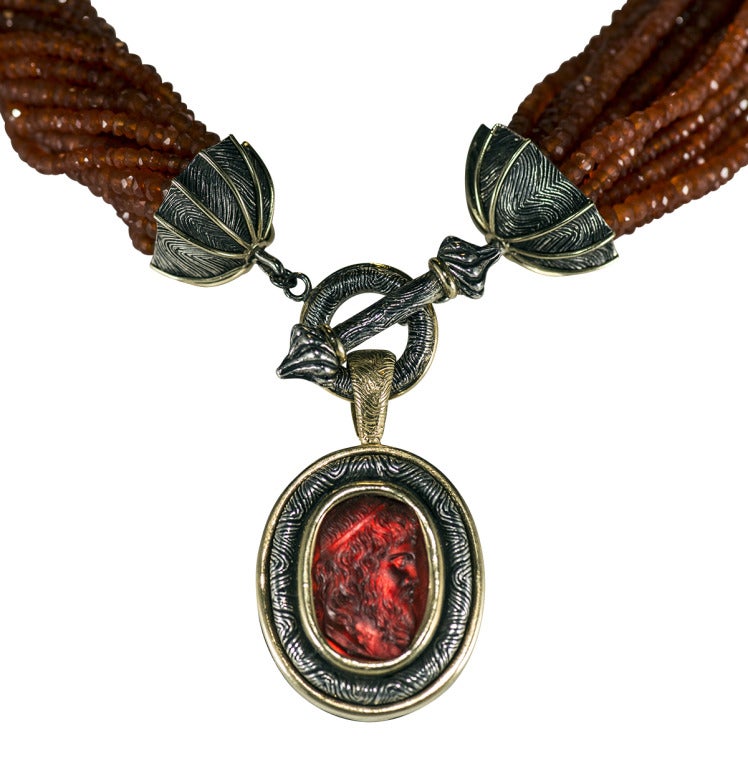 Important Fire Opal Torsade necklace with hand cast toggle closure.  Finely carved details in All Metal work 
Bronze, sterling silver and 18 k gold

Drop is carved cameo glass set in custom  bronze, silver and 18k gold with fine detail carving.(