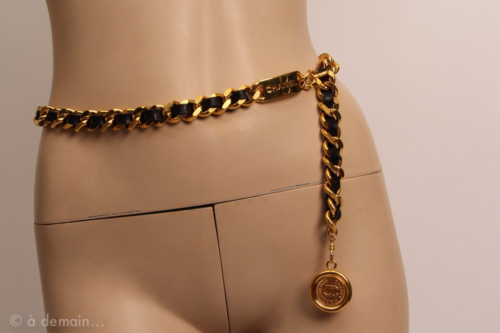 Chanel black leather and gold metal chain belt with the Chanel logo, and one medallion engraved 