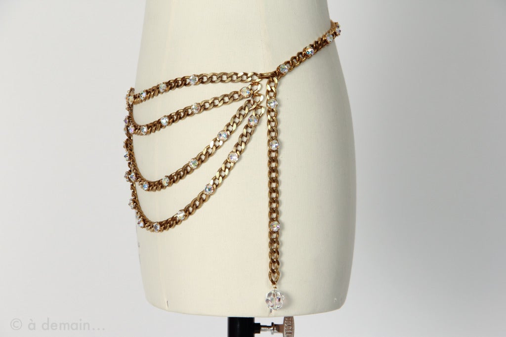 Rare and unsigned Chanel collection model from the 1980s, probably designed for a fashion show.
Chain and strass belt with 4 rows in the front and a pendant on a side.