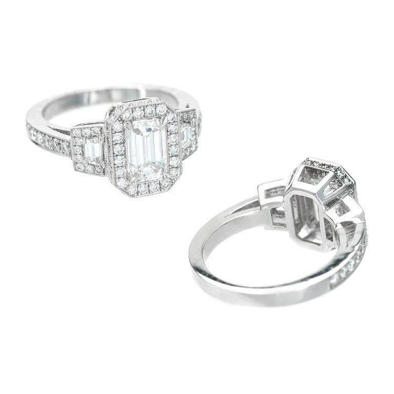 Original Art Deco Emerald step cut center diamond and trapezoid diamonds in a brand new Peter Suchy octagonal rectangular top triple halo design solid Platinum ring. Classic beauty. Excellent condition. Looks great on the hand.

1 Emerald step cut