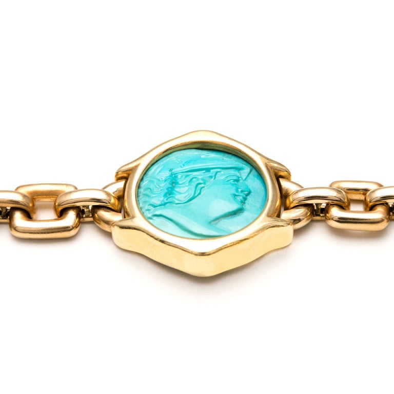 Natural color untreated Turquoise double sided Cameo. The bracelet is handmade in heavy solid 18k gold with a handmade catch and underside safety. 

GIA certified natural untreated Turquoise 21 x 21.5 x 5.35mm green blue double sided carving.