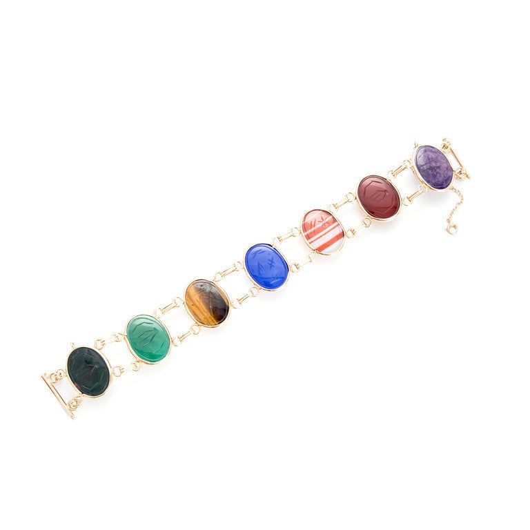 1940's 21mm wide beautiful 14k yellow gold scarab bracelet.  The carved scarab stones are of much finer quality than what we see today.  The Amethyst is a clear translucent purple. The Chrysophase is translucent as well.  All the other colors are