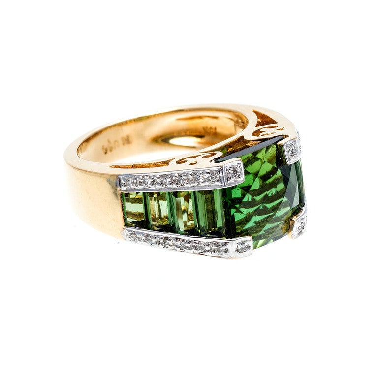 Tourmaline and diamond yellow gold ring from Bellarri. 

9 custom cut top gem green Tourmaline, approx. total weight 8.20cts, VS, center square 10 x 9mm 

28 round full cut diamonds, approx. total weight .18cts, G, VS 

Size 7.5 and