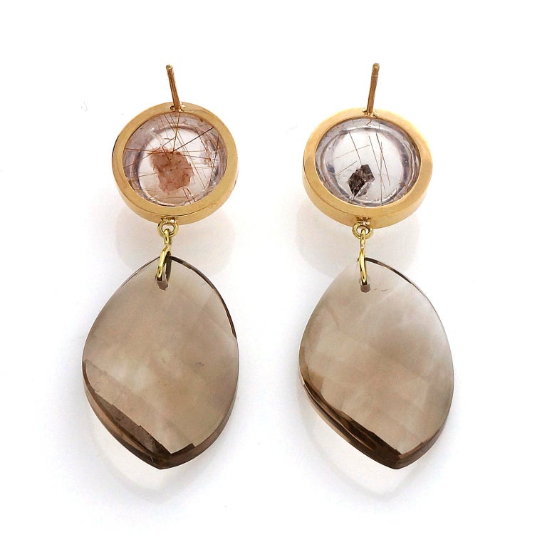 Natural Manifestor Quartz in handmade bezels for pierced ears with simple dangles. Designed and made in the Peter Suchy workshop. Earring backs stamped 18k/750.

2 round cabochon natural slightly smoky Quartz with Rutile Calcite and Iron mineral