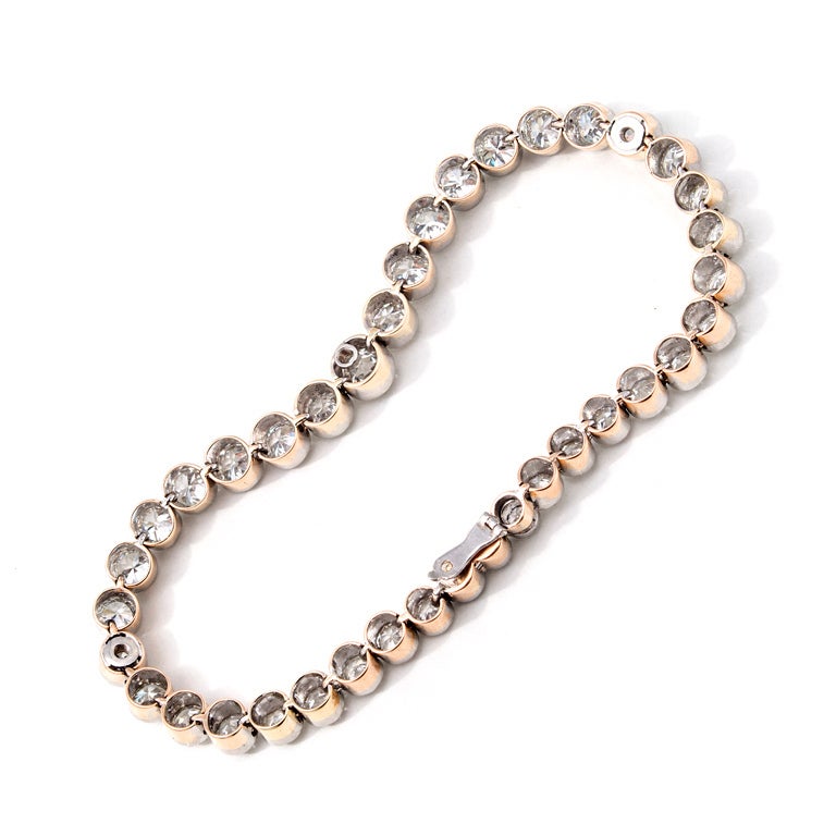 Victorian tube set rose gold and platinum diamond bracelet. circa 1890's. Platinum top half with mil-grain bezels and rose gold base. Underside safety. 

38 old European cut diamonds, approximate total weight 15.00 carats, G to H, SI1 to SI3, 0.12