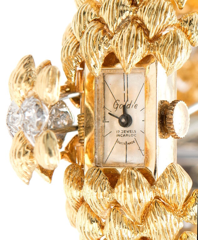 1950's Bombe link domed and textured wristwatch with accent diamonds. Hidden built in catch and center covered watch. The 18k yellow gold lid hinges open to show the 14k Goldie watch. Manual wind. 

96 single cut diamonds. Approx. 1.00ct. H color,
