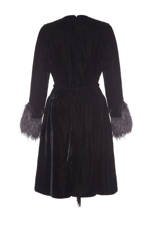 An absolutely stunning 60’s black velvet dress by Christian Dior, London.  Perfect for a winter party, this knee length dress has full-length sleeves which feature black ostrich feathers that extend beyond the cuff.  The same fabulous feather trim