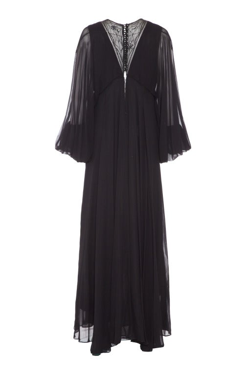 A fantastic dress from iconic British label Jean Varon featuring a sheer netted section to both the back and front of the neckline with spider and web embroidery, beading and sequins.  The outer layer of the dress is black silk chiffon with huge