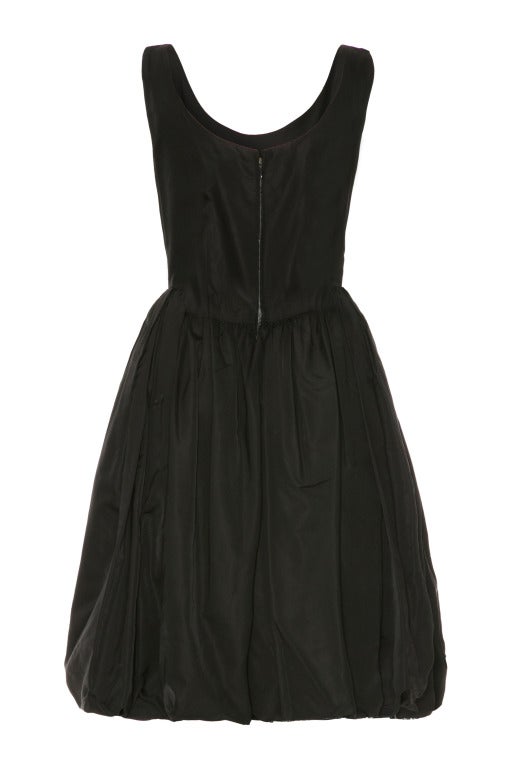 Beautiful black organza dress with white guipure lace underlay in the skirt and pretty sweetheart neckline. 
The midi length bubble skirt is box pleated at the front to reveal the layers of lace.  
Fastens with a side zip closure, this luxurious