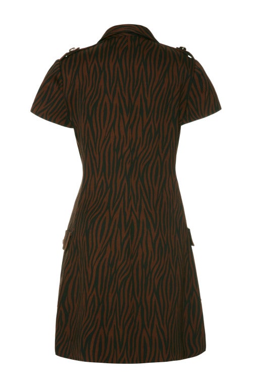 A cute little 80’s mini by Gianni Versace!
This cute dress features a dark jungle/ zebra print in black and maroon, button- down front and two large pockets on the hips. 
With short sleeves and epaulettes this is a very versatile and could be worn