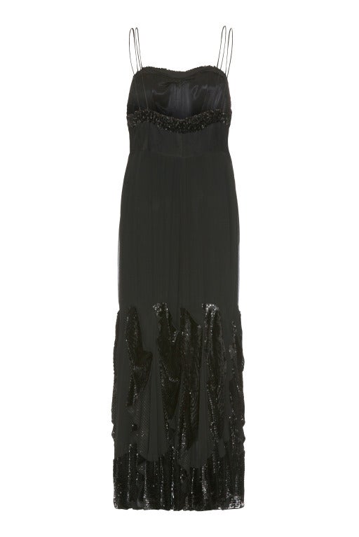 A stunning full-length flapper dress of haute couture quality.  This dramatic black chiffon gown is fully lined in black satin and features sequined panels attached around the skirt creating beautiful movement in the dress.  There is also a sequined