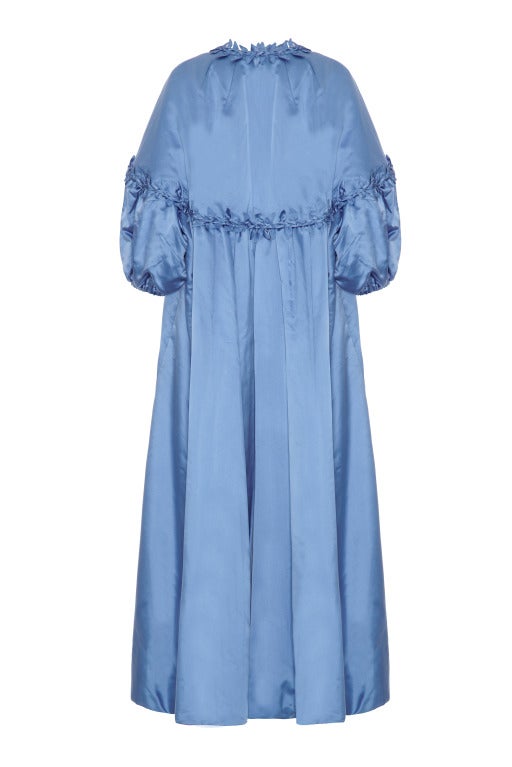 Magnificent full-length 1950s couture evening coat in sky blue silk.  This piece was acquired from a very wealthy Hamptons estate and is a real show stopper. Made in the same blue silk, it features a pretty braided cord trim with leaves. It fastens