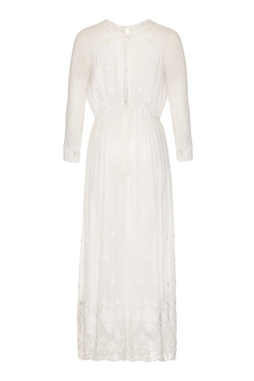 A stunning full length Edwardian dress in a sheer white cotton with amazing large satin stitch embroidery featuring grapes, leaves and flowers on the bodice and skirt.  
This extremely delicate and decorative piece also features lace panels, eyelet