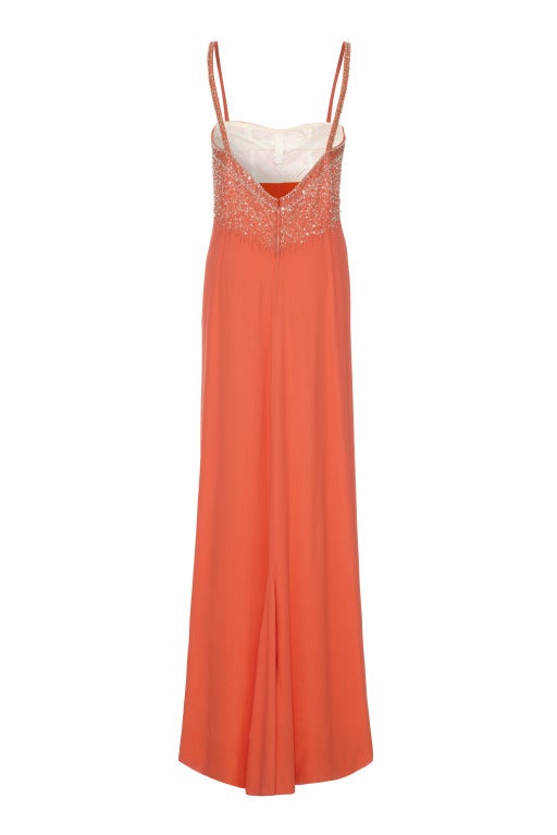 A beautiful full-length gown in the softest peach crepe.  
This dress is only lined around the bust so the crepe fabric falls beautifully to the floor. It features exquisite embroidery, beading and rhinestone detailing to the bust and straps with a