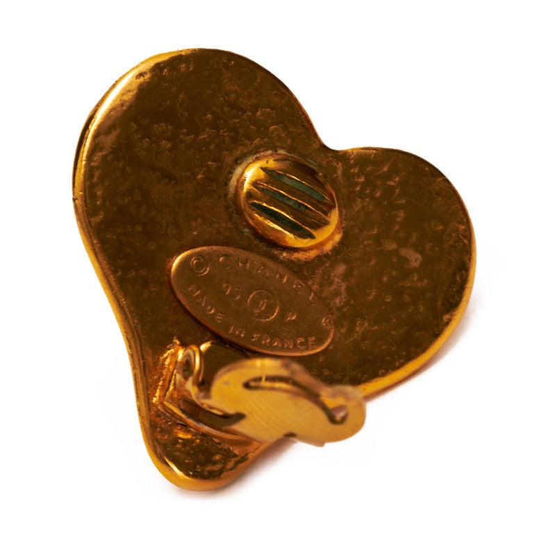 Absolutely charming vintage clip on Chanel earrings from the very popular 95P (spring) collection. The flat hammered gold tone metal hearts are shaped slightly off left making it sit on the ear beautifully. The earrings features cabochon white pearl