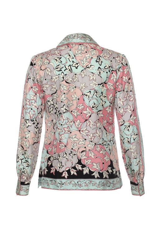 This is a spectacular 1960's jacket style blouse in a scarf print by Pucci.  The silk shirt is in such good condition it could pass for new and features a light blue, lilac, pink and black scarf style design.  It fastens up the front with matching